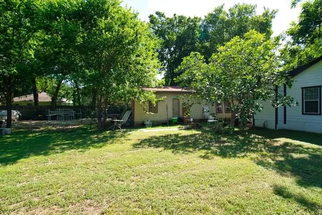 a backyard of a house with yard and trampoline