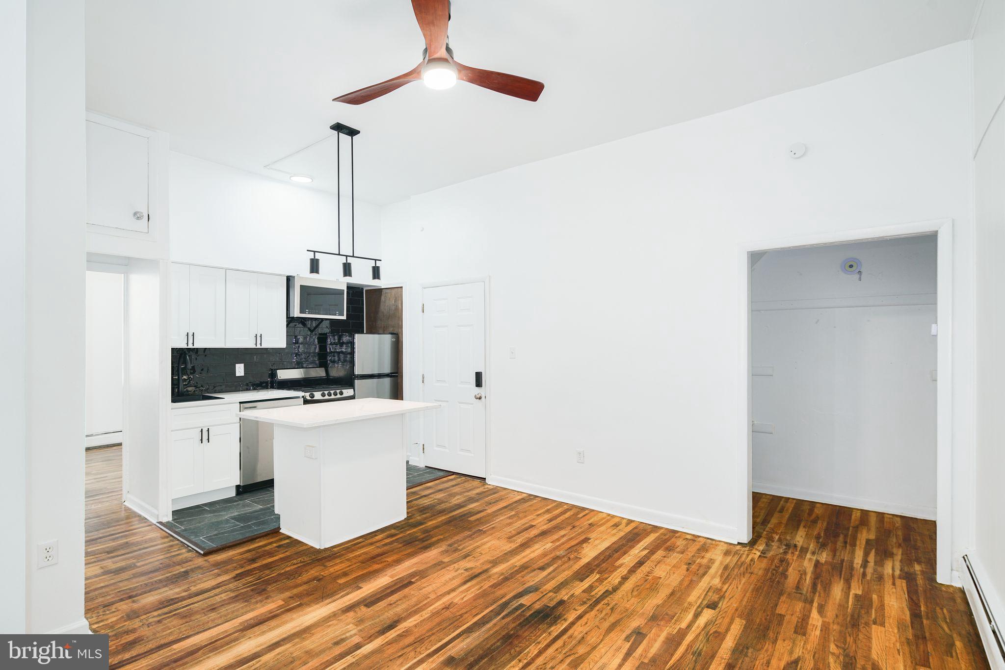 1024 Pine Street, Unit 2 Philadelphia, PA 19107 - Photo 4 of 7 a view of a kitchen with stainless steel appliances wooden floor and chair
