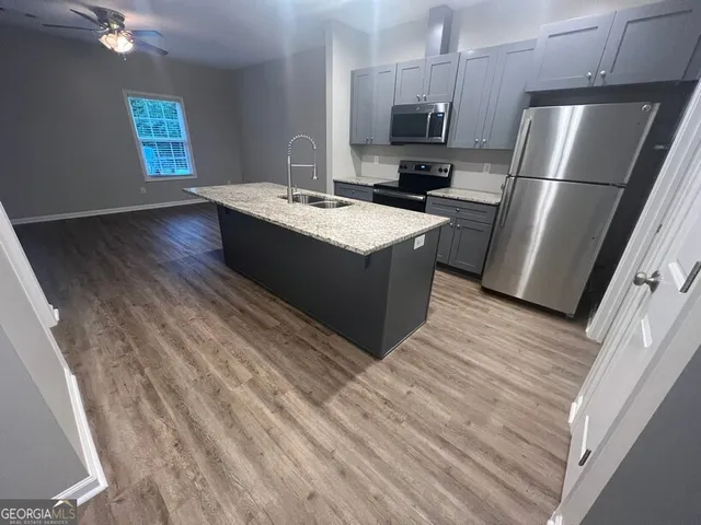 a kitchen with a refrigerator sink and wooden floor