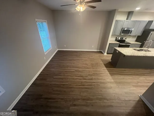 a view of an empty room with wooden floor and closet