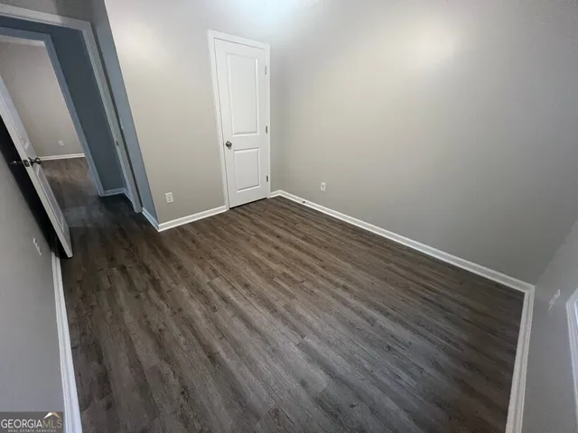 a view of a room with wooden floor and cabinets