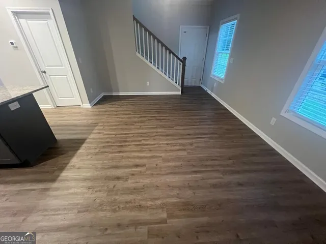 a view of entryway and kitchen with wooden floor
