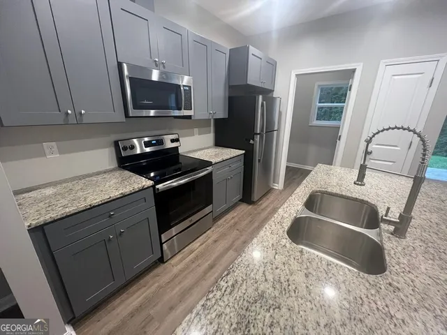 a kitchen with kitchen island sink refrigerator microwave and stove