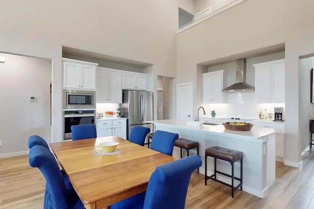 a living room with furniture a large window and a chandelier