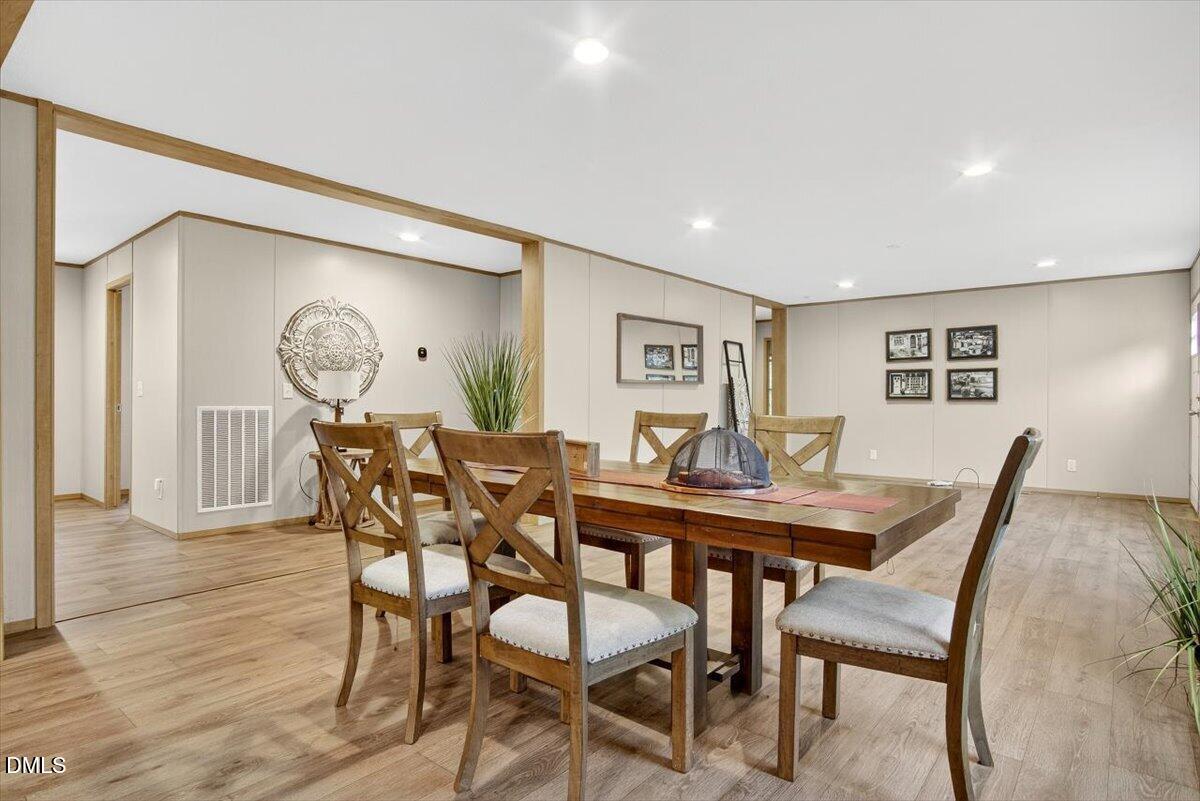 532 Plum Nutty Road Henderson, NC 27537 - Photo 11 of 38 a view of a dining room and livingroom with furniture wooden floor and a rug
