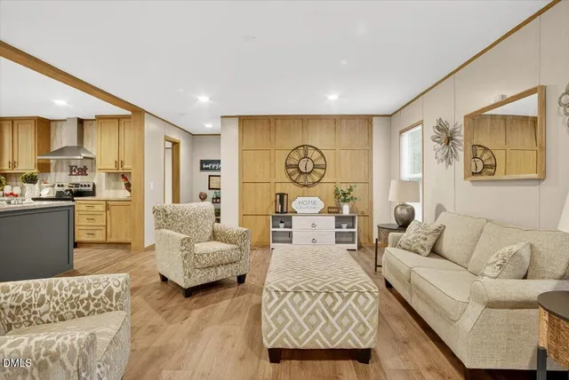 a living room with furniture kitchen view and a large window