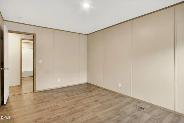 a view of an empty room with wooden floor