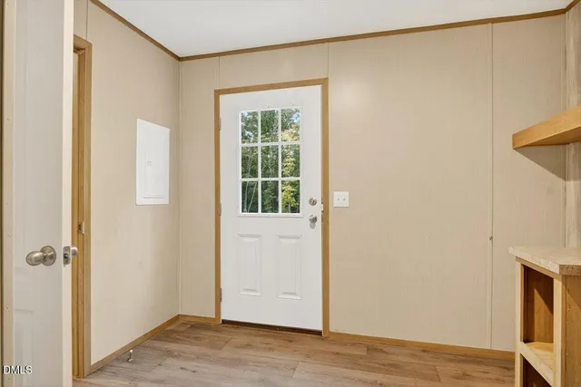 a view of an empty room with wooden floor and closet