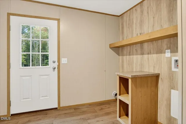 an entryway with wooden floor and cabinet
