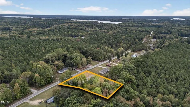 an aerial view of a residential houses with city and green space