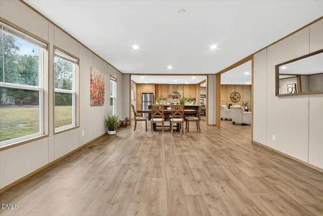 a view of a livingroom with furniture wooden floor and a large window