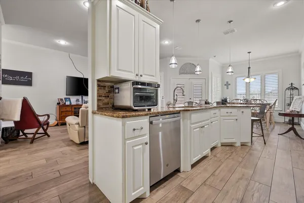 a kitchen with white cabinets and sink