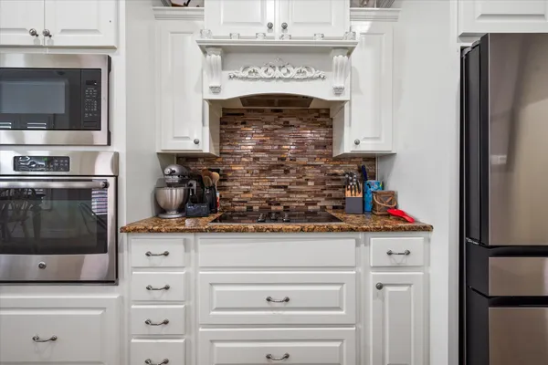 a kitchen with stainless steel appliances granite countertop a stove and a microwave with cabinets