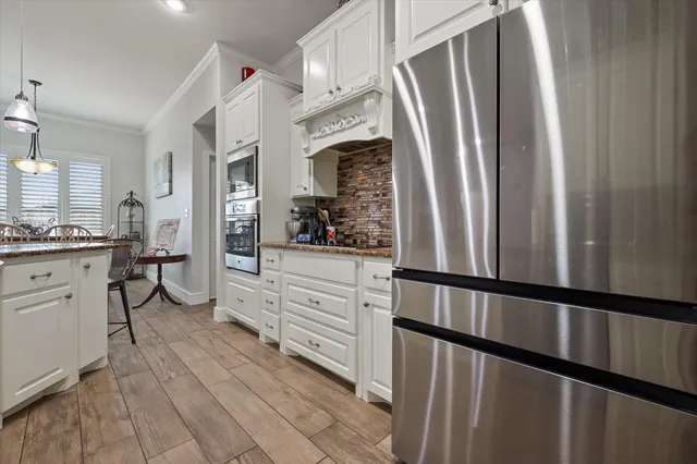 a kitchen with stainless steel appliances a refrigerator sink and cabinets