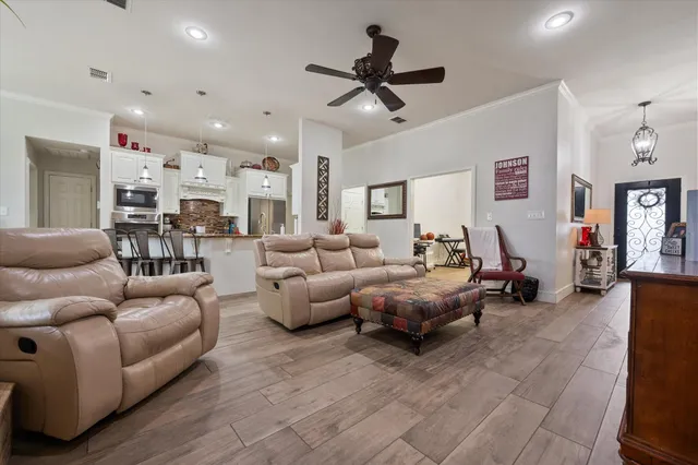 a living room with furniture and a ceiling fan