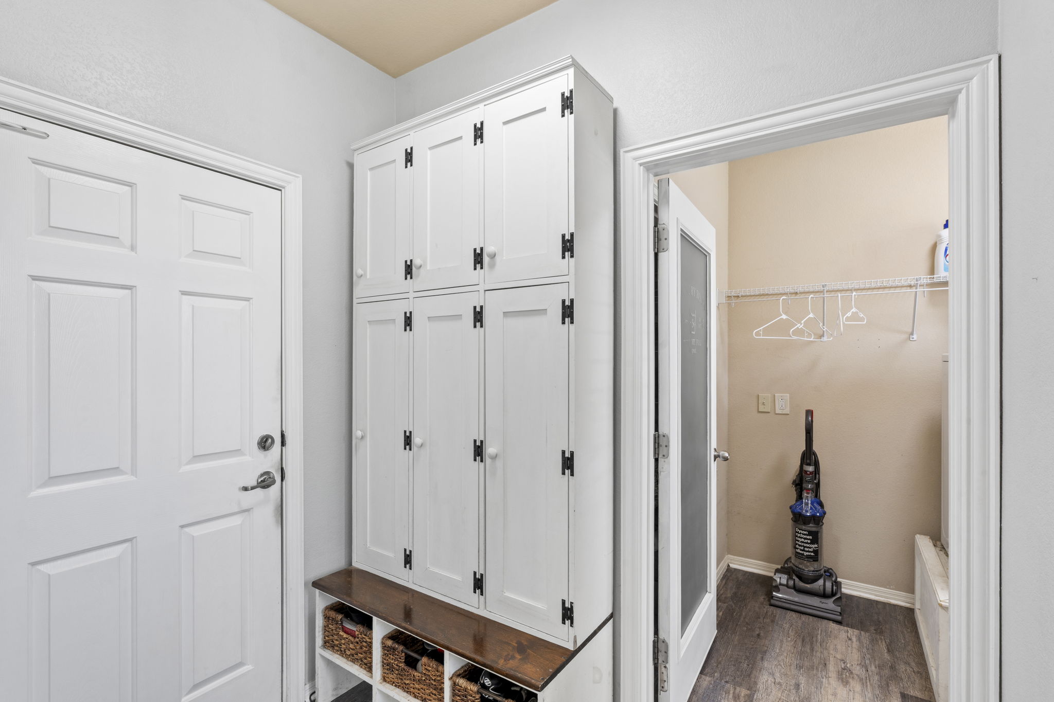 227 Sandstone Trail Buda, TX 78610 - Photo 30 of 33 Custom built-in storage unit featuring white cabinetry, dark hardware, and a wood-finish bench