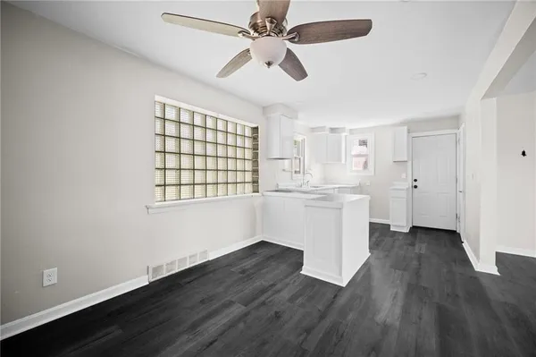 a view of an empty room with window and wooden floor