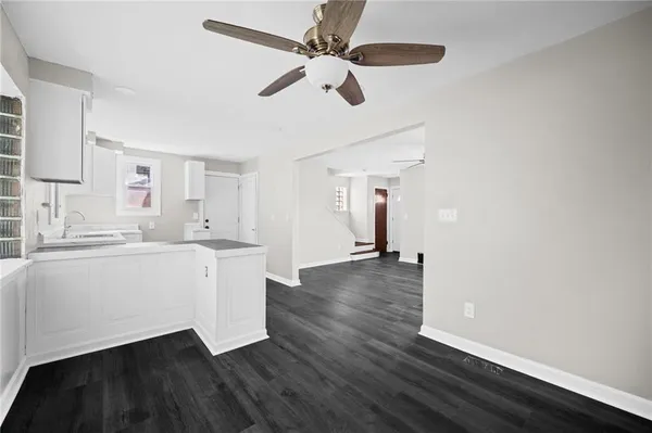 a room with a sink cabinets wooden floor and a window