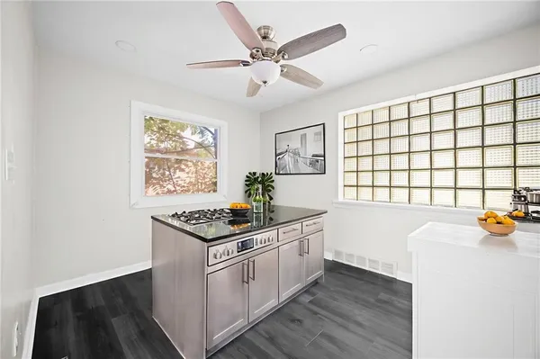 a kitchen with granite countertop a stove cabinets and wooden floor