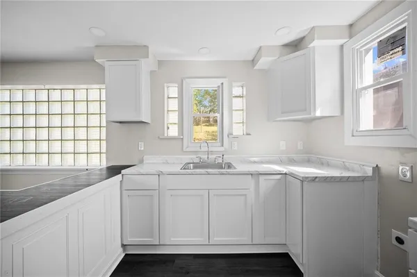a kitchen with a sink and wooden floor
