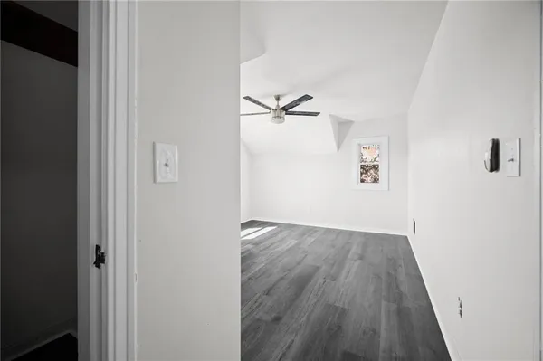 an empty room with a window and a ceiling fan