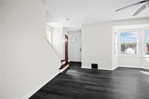 wooden floor in an empty room with a window