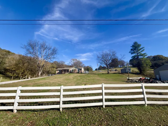 a front view of a house with a garden and trees