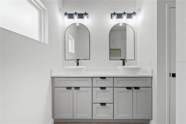 a bathroom with 2 sink and a mirror