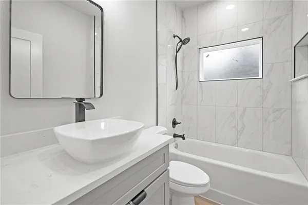 a bathroom with a sink a toilet and shower