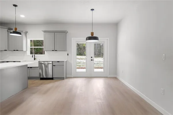 a kitchen with stainless steel appliances a sink a stove a refrigerator cabinets and wooden floor