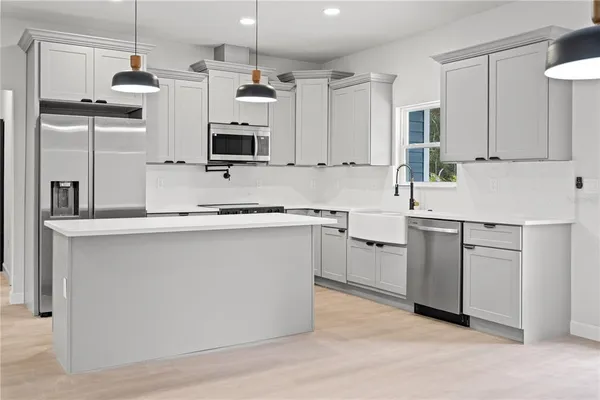a kitchen with a sink window and stainless steel appliances