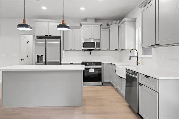 a kitchen with kitchen island white cabinets and stainless steel appliances