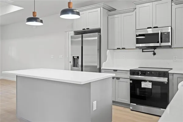 a kitchen with stainless steel appliances a stove microwave and cabinets