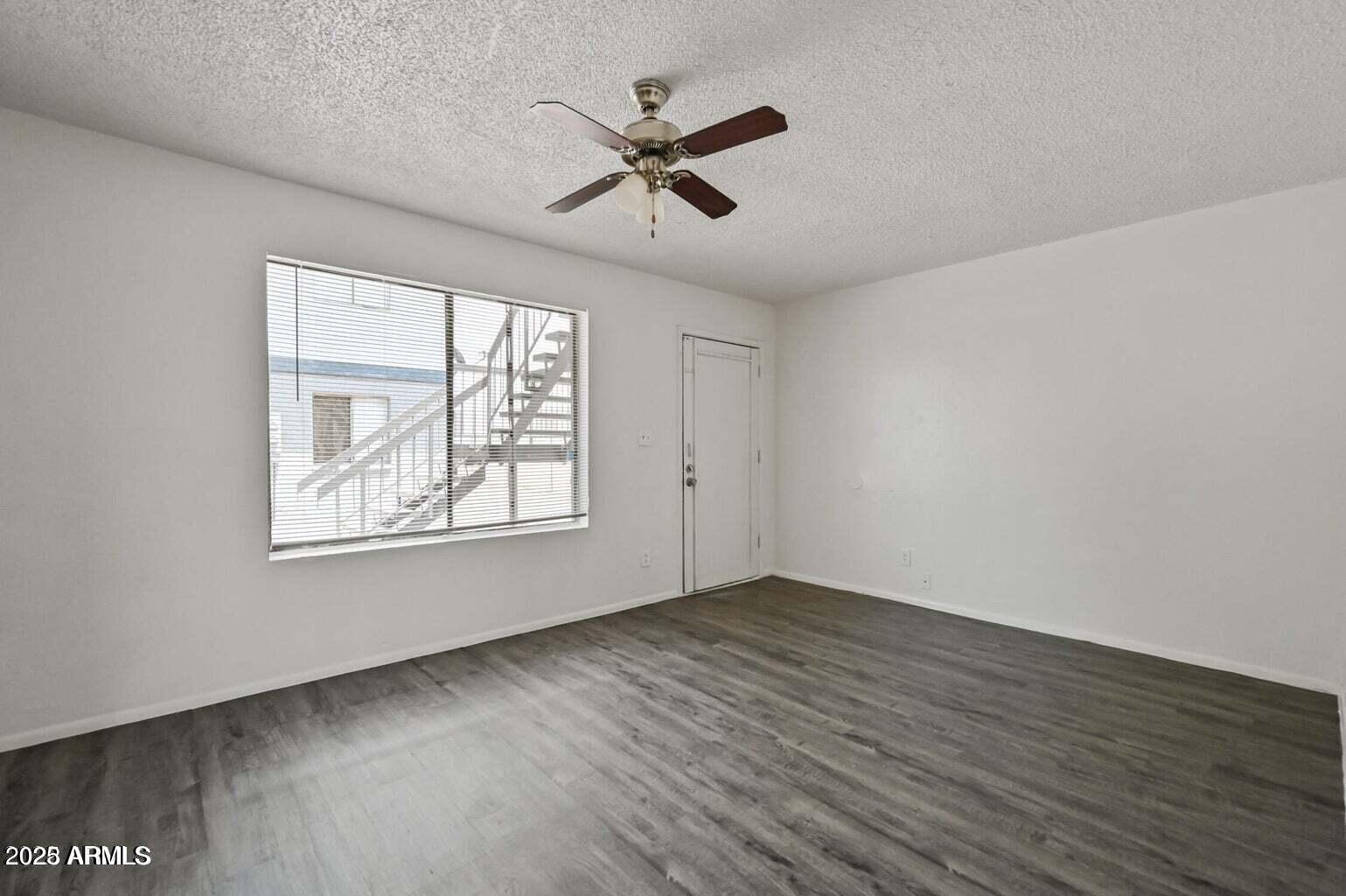 719 East Roeser Road, Unit 201 Phoenix, AZ 85040 - Photo 5 of 13 a view of an empty room with wooden floor and a window