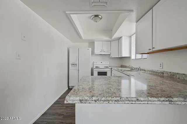 a kitchen with stainless steel appliances granite countertop a sink stove and white cabinets