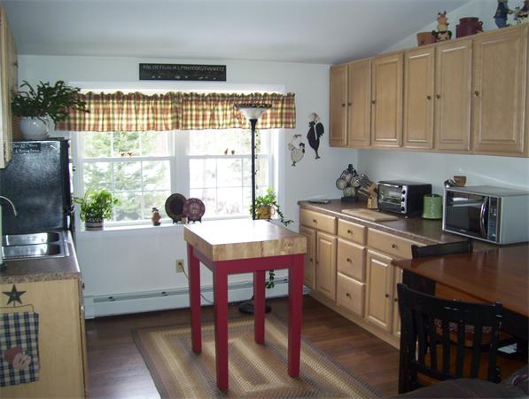 50 Paddock Road Rutland, MA 01543 - Photo 3 of 22 a kitchen with a table chairs and cabinets