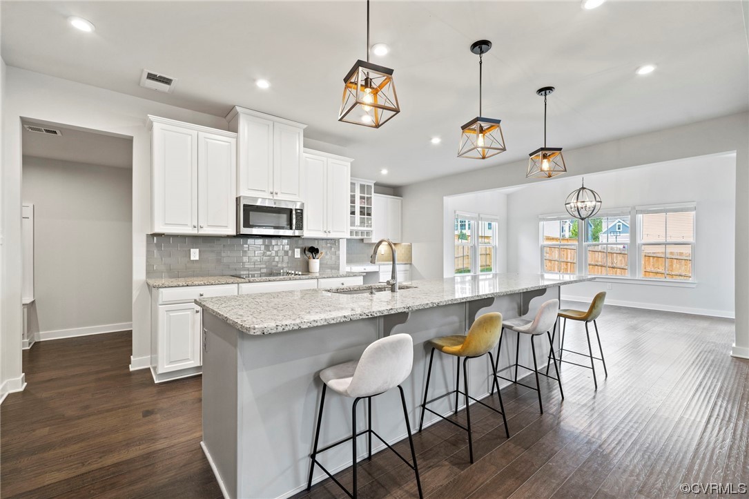 4125 Cambrian Circle Midlothian, VA 23112 - Photo 4 of 21 a kitchen with kitchen island granite countertop a stove a sink a dining table and chairs with wooden floor