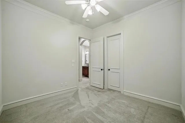 an empty room with a chandelier fan and closet area