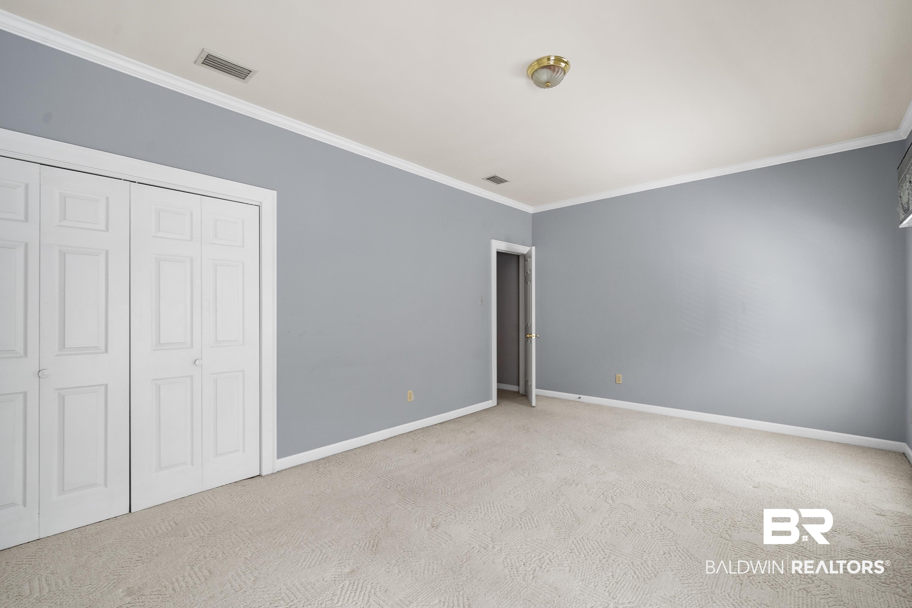 4272 Bit And Spur Road, Unit 12 Mobile, AL 36608 - Photo 26 of 34 Unfurnished bedroom featuring crown molding, carpet, baseboards, and a closet