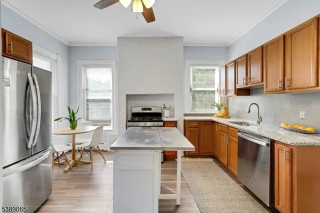 a kitchen with stainless steel appliances granite countertop a refrigerator sink and stove