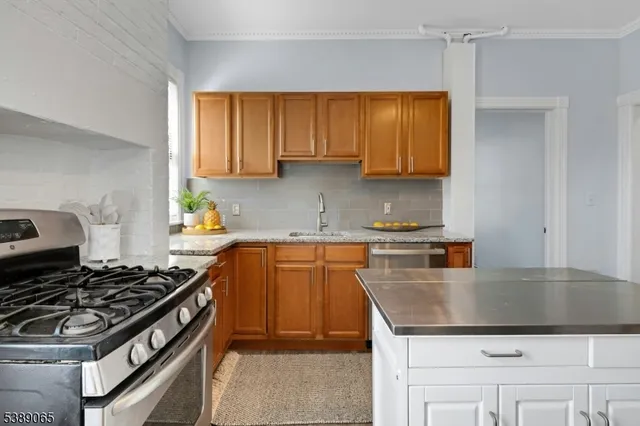 a kitchen with granite countertop a sink stove and cabinets