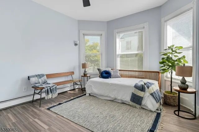 a bedroom with a bed table chair and a window