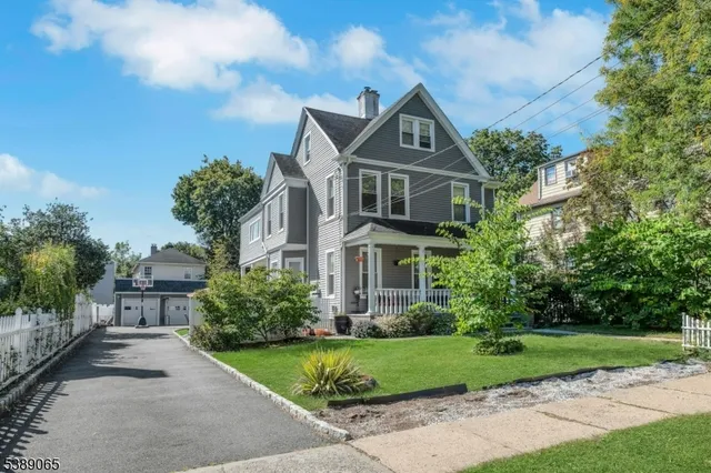 a front view of a house with a yard and trees