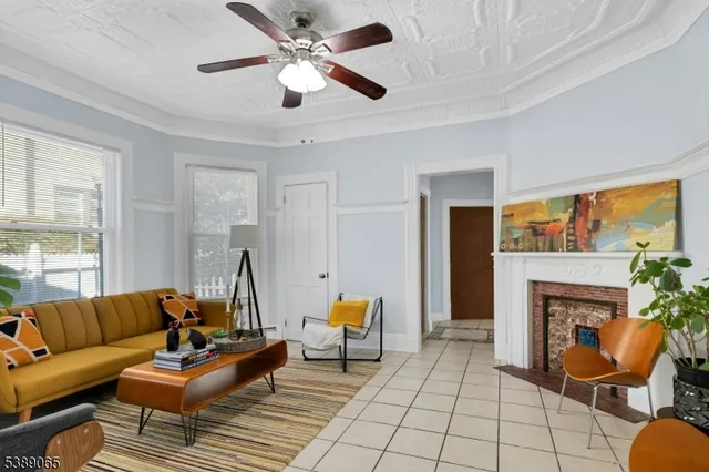a living room with furniture a fireplace and a large window