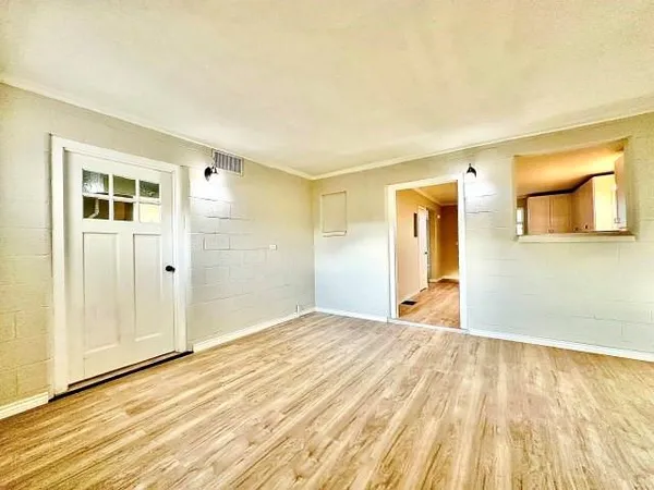 a view of empty room with wooden floor and entryway