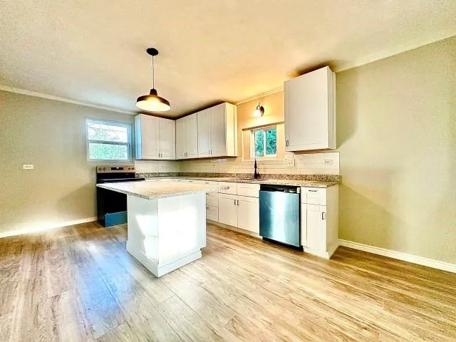 a kitchen with stainless steel appliances granite countertop a stove a sink and a refrigerator