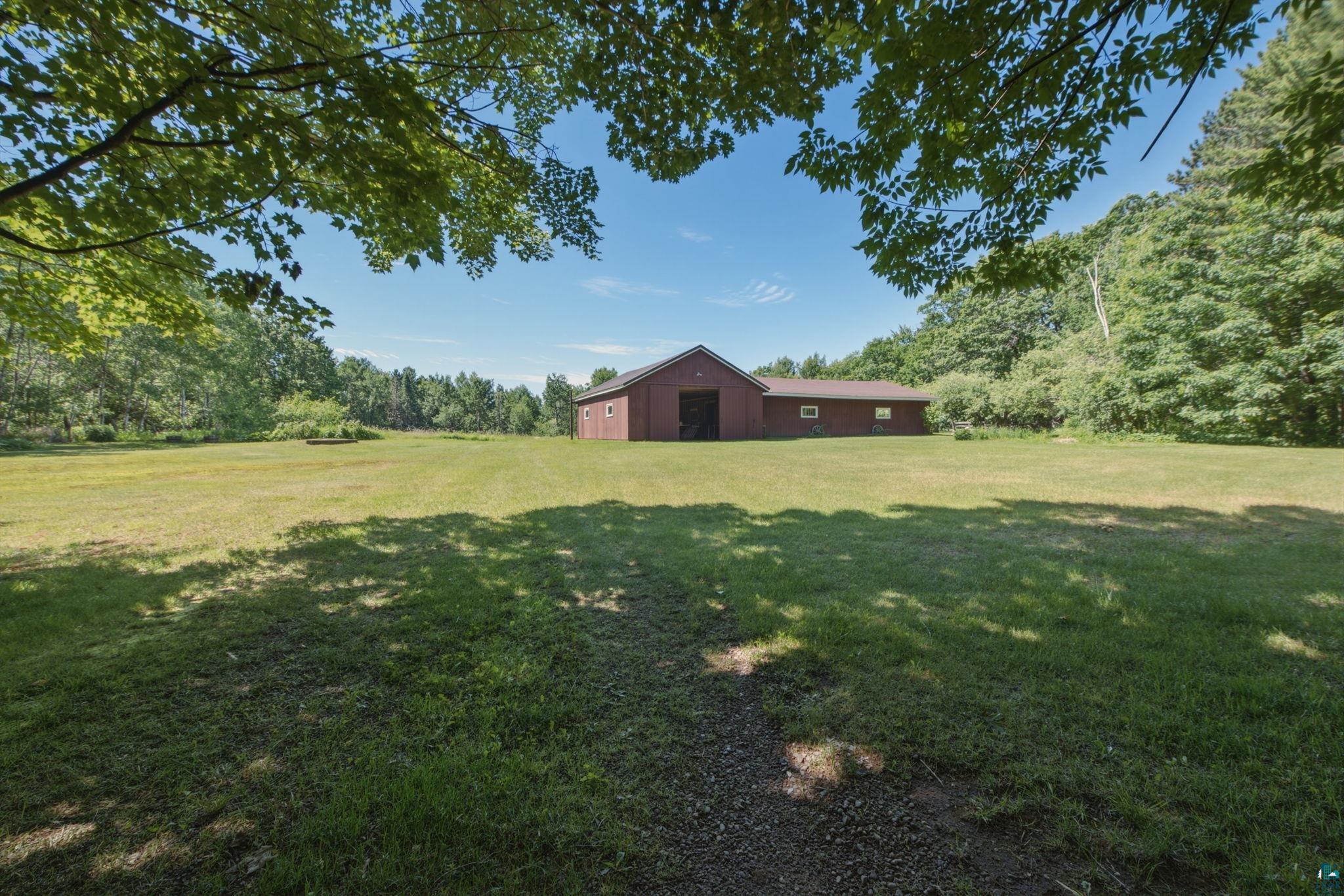 27485 South Kane Road Ashland, WI 54806 - Photo 21 of 35 Expansive grassy grounds featuring a red barn-style structure with a metal roof