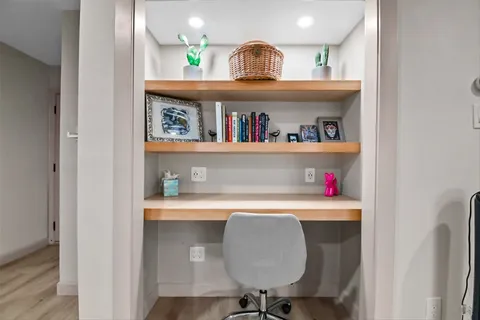a view of cabinets a sink and dishwasher in a white cabinet with wooden floor