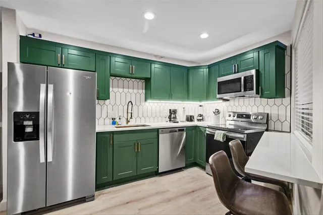a kitchen with cabinets a sink and stainless steel appliances