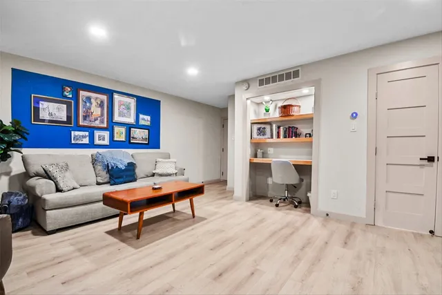a living room with furniture and a dresser